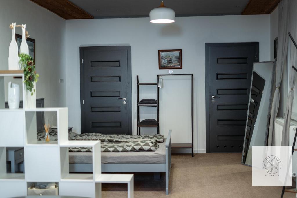 Pokój z dwoma czarnymi drzwiami i lustrem w obiekcie Apartmán Kompas w mieście Spiskie Podgrodzie