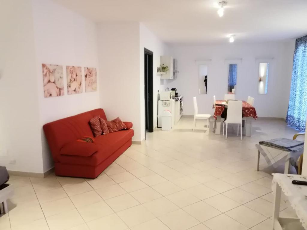 sala de estar con sofá rojo y comedor en Alloggio VR est via Belfiore, en Lavagno