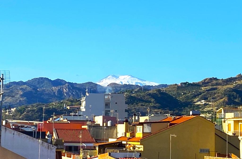 Blick auf eine Stadt mit einem Berg im Hintergrund in der Unterkunft La Terrazza Bella Sicula in Furci Siculo