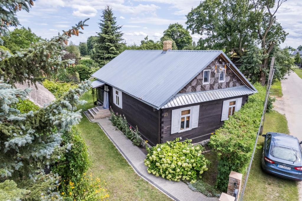 an overhead view of a black house with a car parked in front at prawdziwy wiejski domeczek in Hajnówka