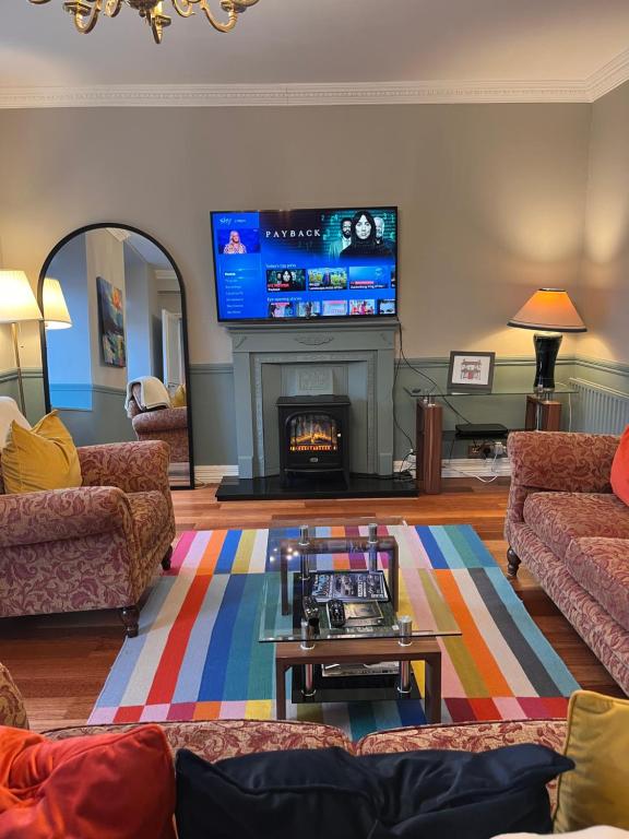a living room with a fireplace and a tv at No 10 Bridge Street - Town Centre Apartment in Westport