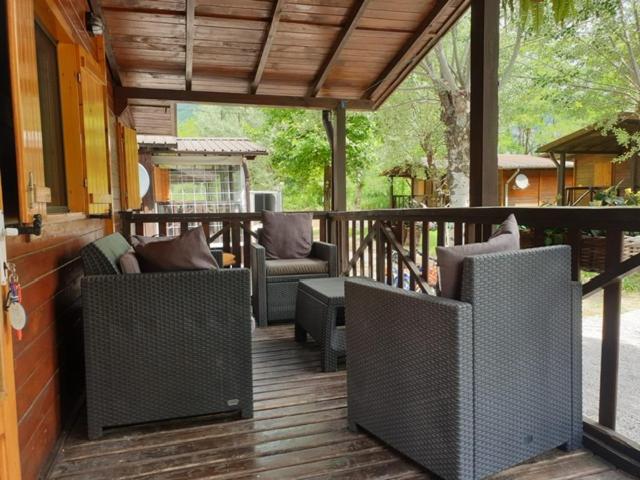 un porche con sillas y una mesa en una terraza en Brevar Vakantie - Porlezza, en Porlezza
