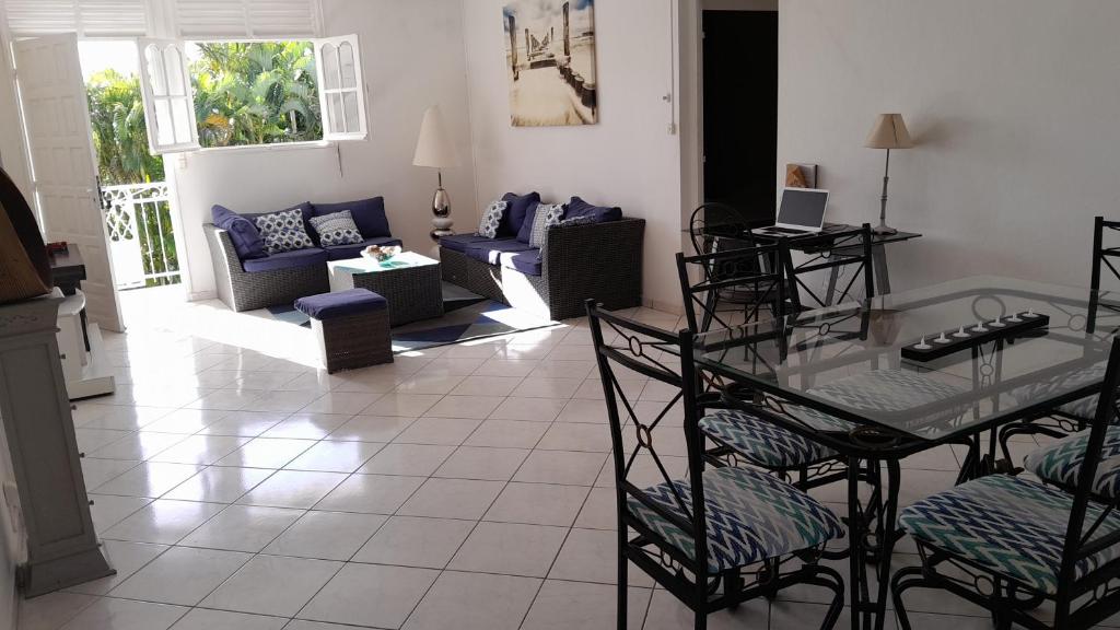 sala de estar con sofá, mesa y sillas en Coconing logements studios et maisons, en Sainte-Anne