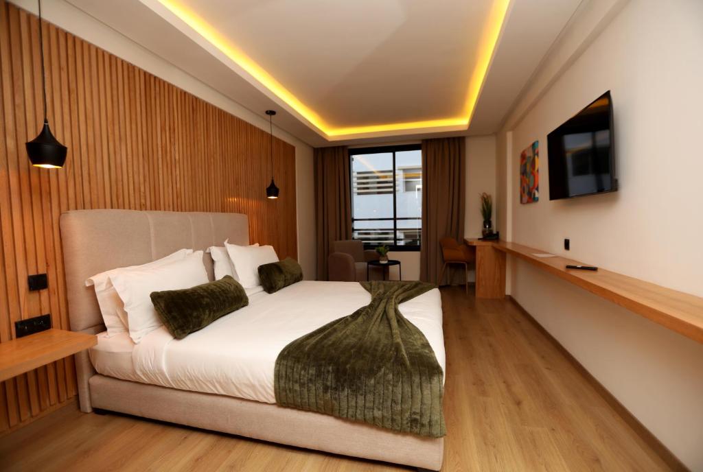 een slaapkamer met een bed en een tv aan de muur bij Unico Hotel & Spa Casablanca in Casablanca