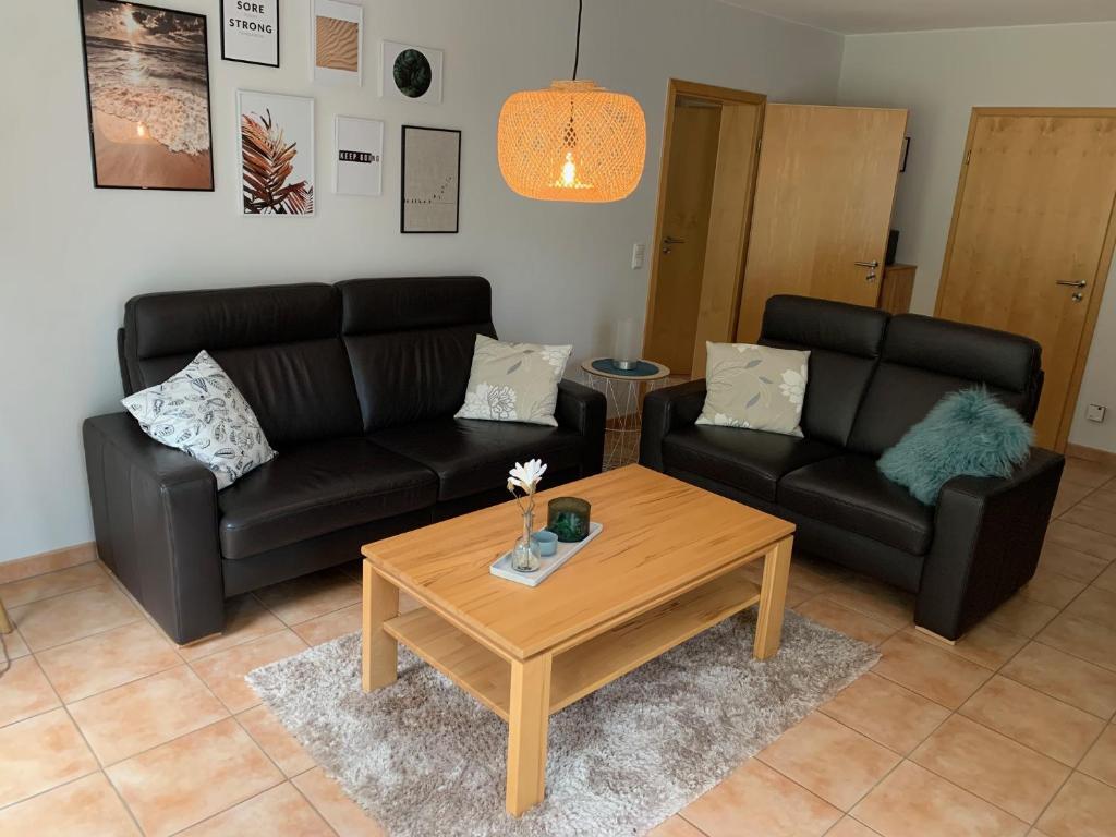 Sala de estar con 2 sofás y mesa de centro en Ferienwohnung „Fiordaliso“, en Schweich