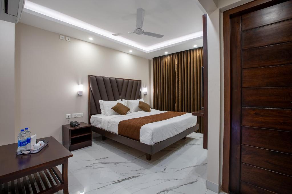 1 dormitorio con 1 cama y puerta de madera en PARKKAVAN TOWERS, en Tiruchchirāppalli
