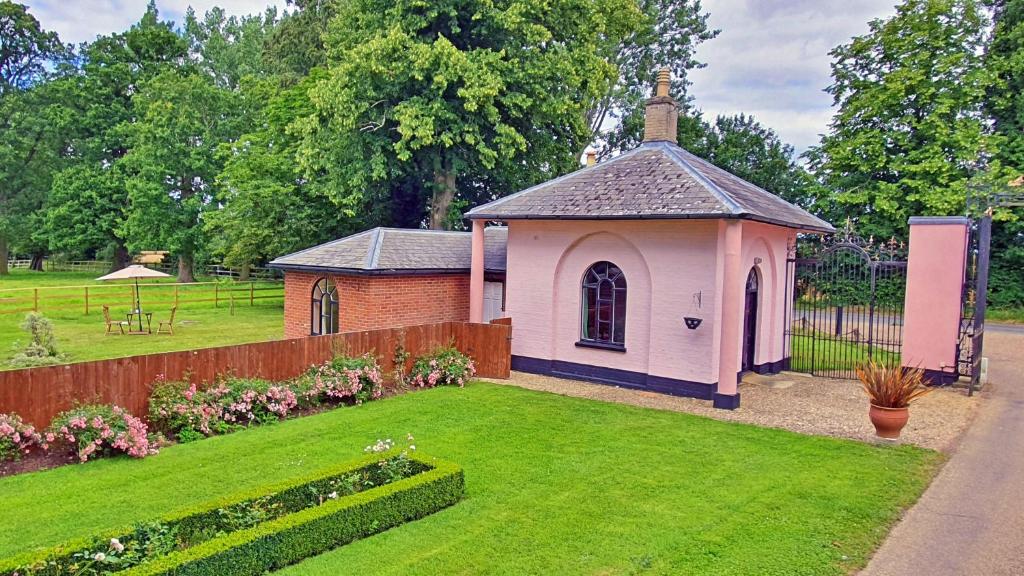 une petite chapelle dans une cour avec une clôture dans l'établissement The Gate House, à Wymondham