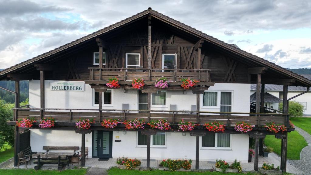 un edificio con un balcón con flores. en Ferienwohnungen Hollerberg Wohnung 1, en Regen