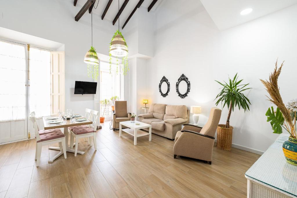 uma sala de estar com um sofá e uma mesa em Apartamento Jazmín em Málaga