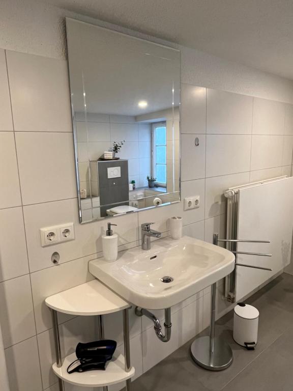 a white bathroom with a sink and a mirror at Ferienwohnungen am Markt - direkt am Historischen Marktplatz in Eschwege