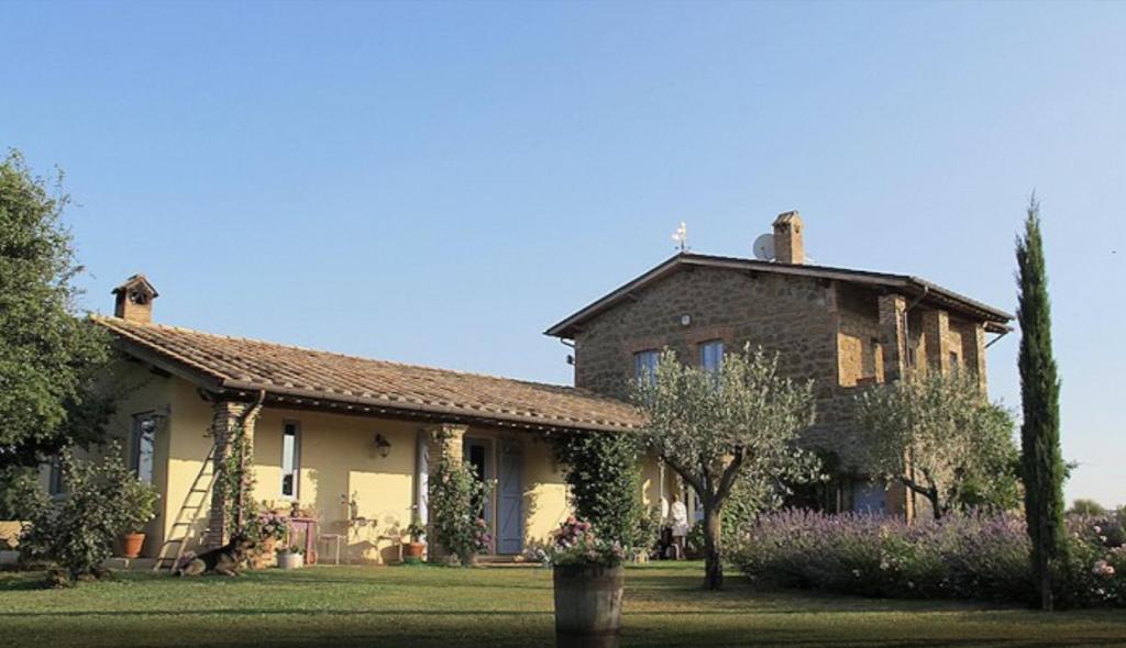 a large brick house with a garden in front of it at Casale del Rosmarino - Monolocale Melograno in Montefiascone