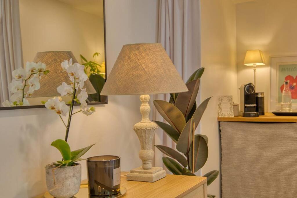 una lampada seduta su un tavolo con dei fiori di Modern self-contained Studio with own access in Stroud Green a Londra