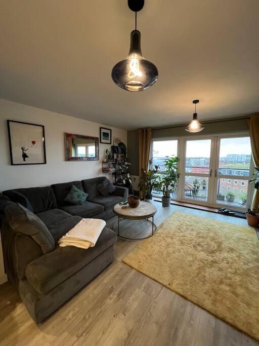 a living room with a couch and a table at A cosy apartment near Crawley Station/Gatwick Airport in Crawley