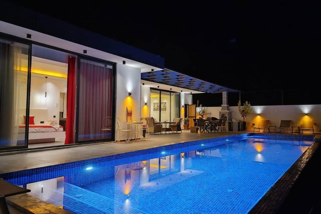 a large swimming pool in a house at night at Villa Serengeti / Kalkan in Kaş