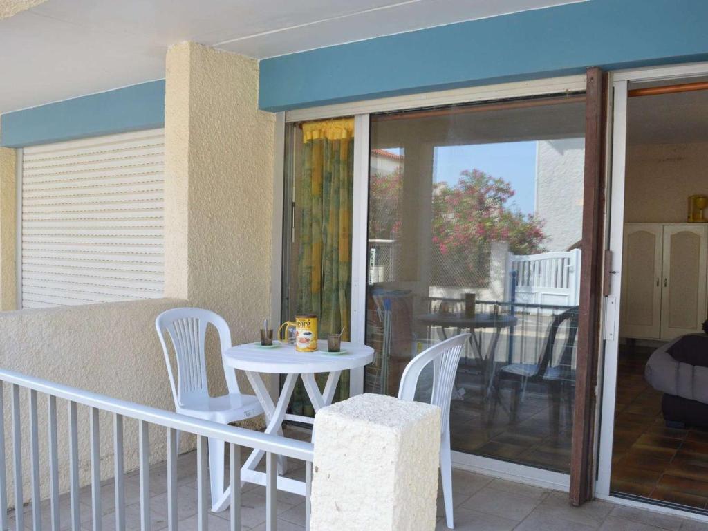 un balcon avec une table et des chaises sur un balcon dans l'établissement Studio en RDC à 250m de la plage - Saint Pierre la Mer, 2 couchages, animaux acceptés - FR-1-229D-232, à Saint Pierre La Mer