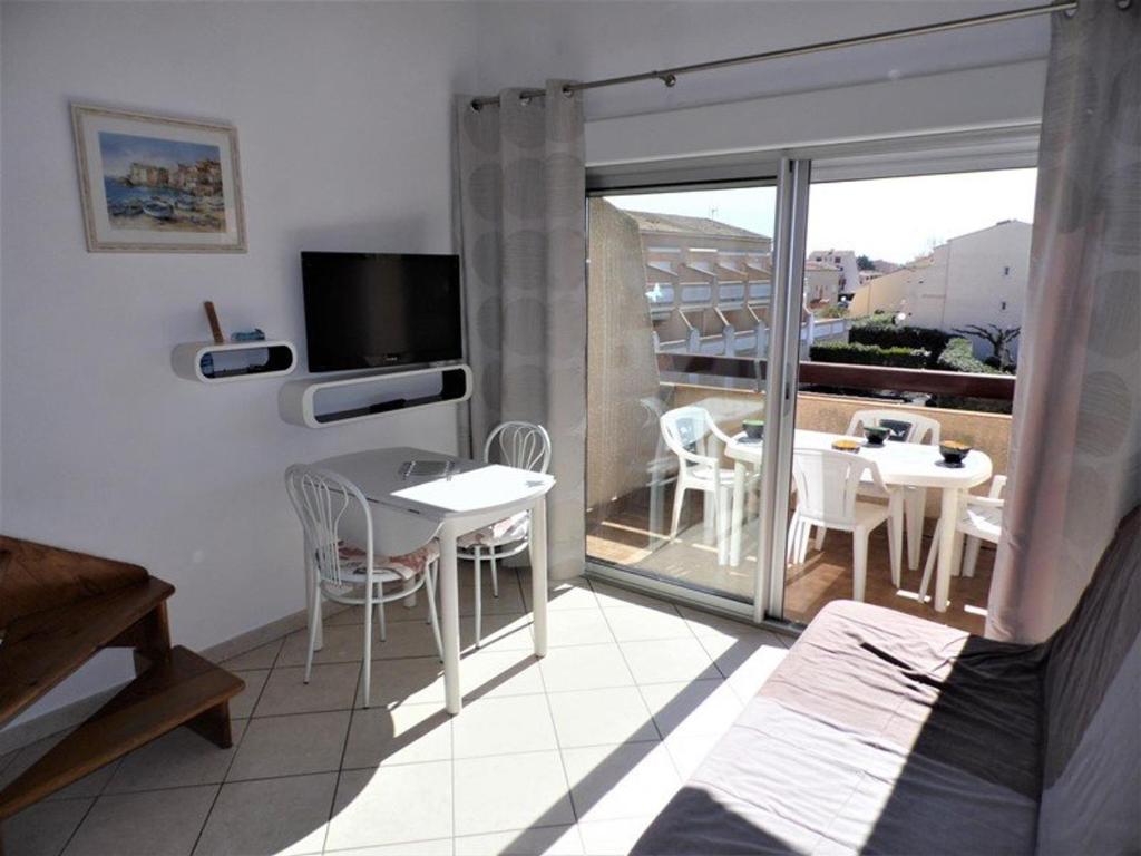 une chambre avec un balcon avec une table et des chaises dans l'établissement Charmant T2 climatisé avec mezzanine, terrasse et piscine, idéal pour 4-6 personnes - FR-1-326-430, à Le Castellas