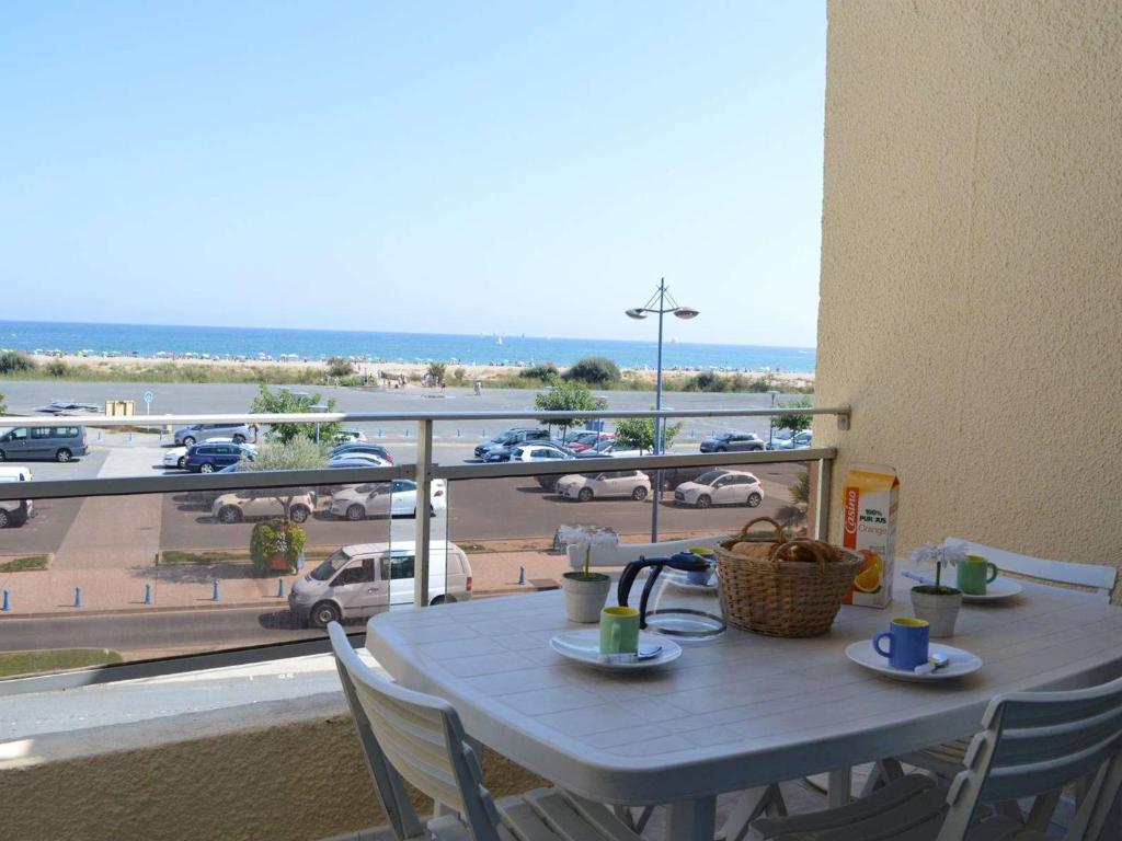 una mesa y sillas con vistas a un aparcamiento en Appartement Fleury-Saint-Pierre-la-Mer, 1 pièce, 4 personnes - FR-1-229D-45 en Fleury