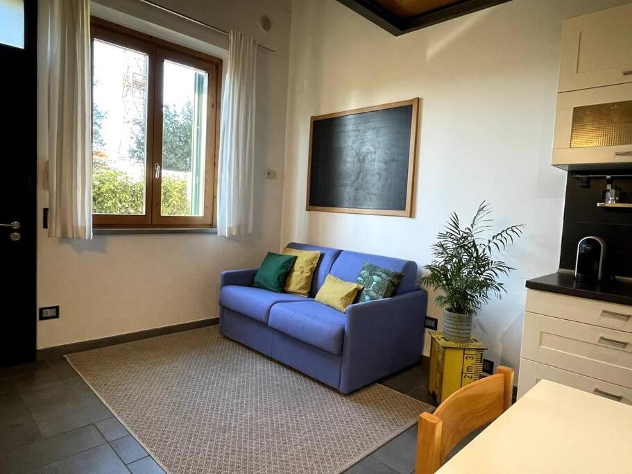 sala de estar con sofá azul y ventana en Casa giordi - intero appartamento, en Empoli