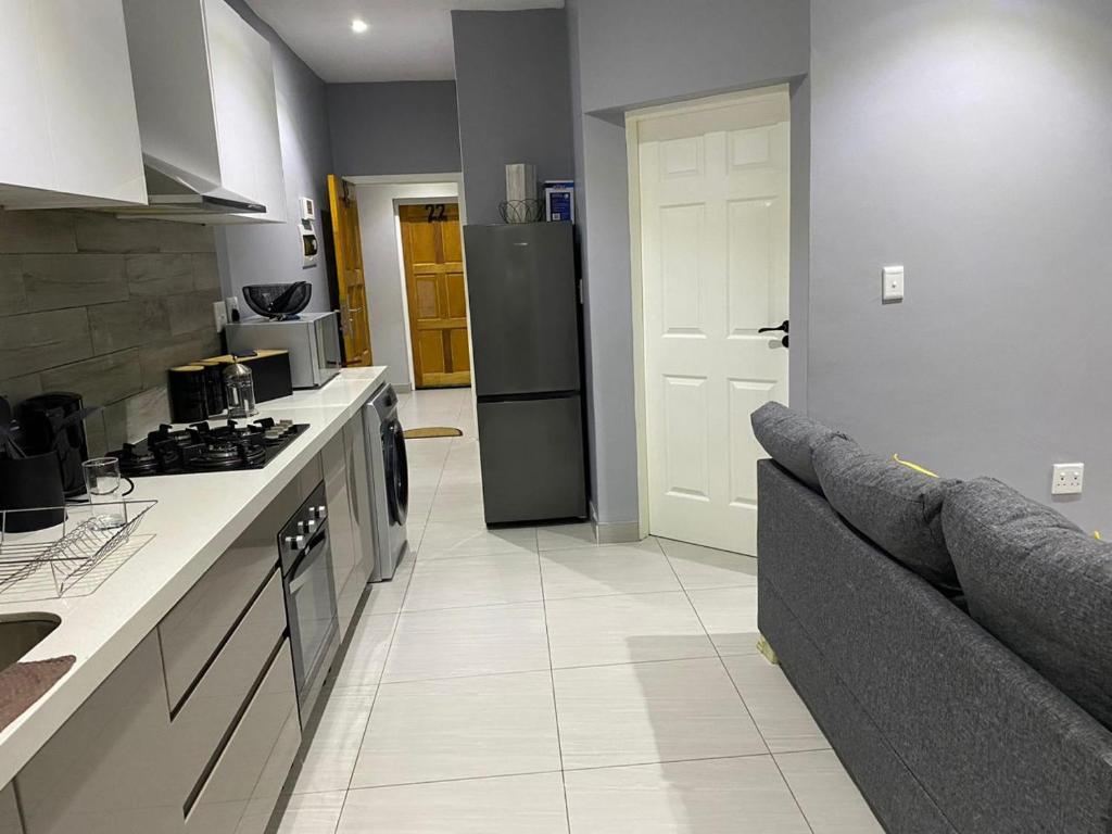 a kitchen with a couch and a stove and a refrigerator at Ongwe Complex - Holiday Apartment in Swakopmund