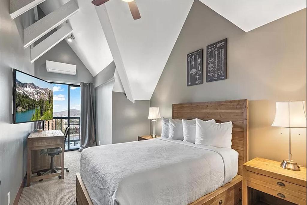 a bedroom with a large bed and a tv at Slope-Side Serenity Ski-In Ski-Out Gem with Pool in Park City
