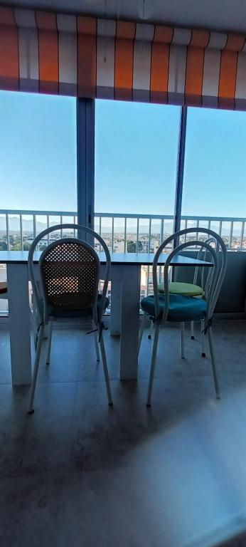 Duas cadeiras sentadas numa mesa numa varanda em Nautilus studio au port avec loggia et parking em Saint-Cyprien