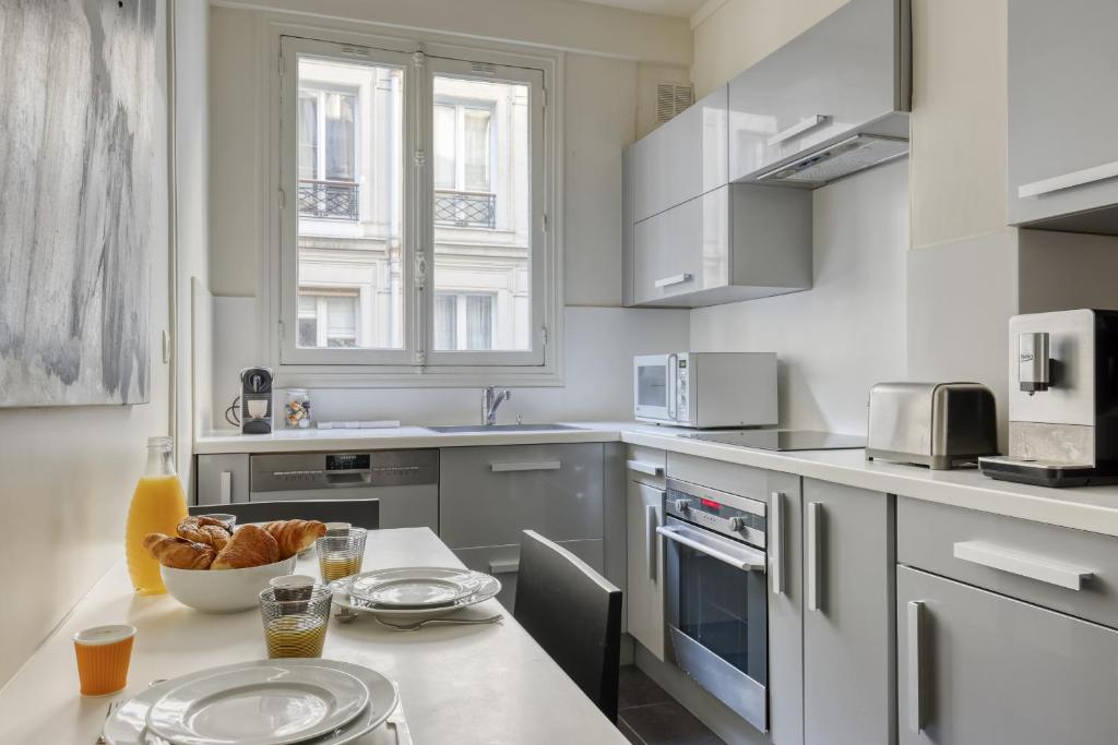 a kitchen with a table with a bowl of bread on it at Gorgeous and large flat in the heart of Paris 09 in Paris