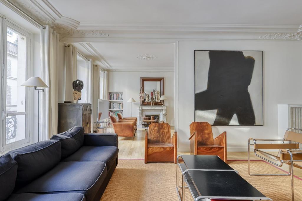 a living room with a black couch and chairs at Gorgeous and large flat in the heart of Paris 09 in Paris