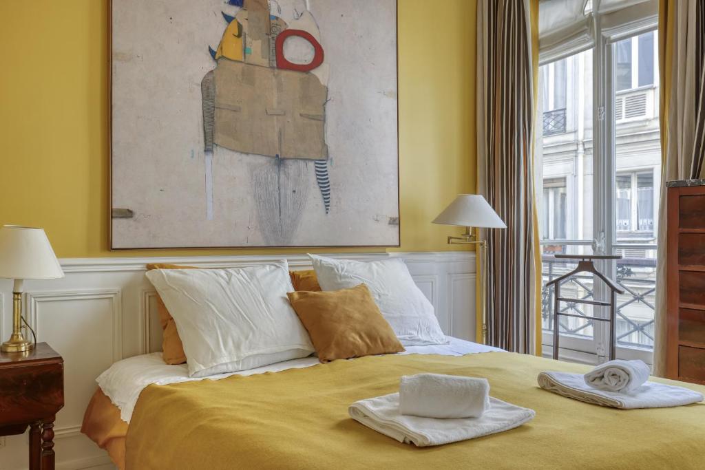 a bedroom with a bed with two towels on it at Gorgeous and large flat in the heart of Paris 09 in Paris