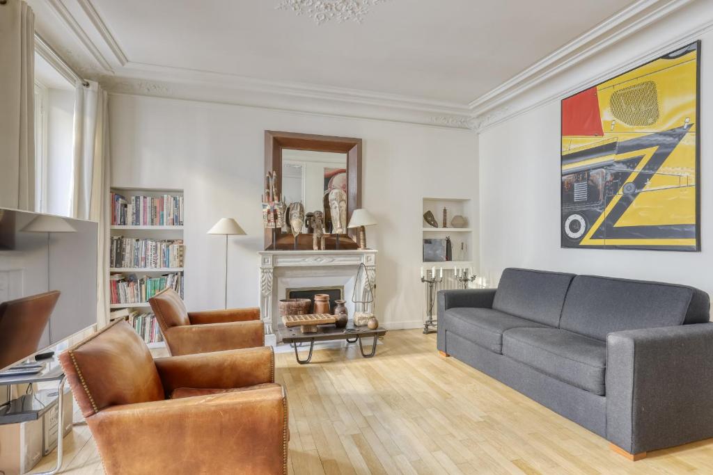 a living room with a couch and a fireplace at Gorgeous and large flat in the heart of Paris 09 in Paris