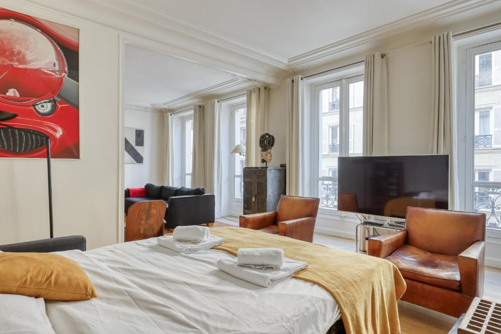 a bedroom with a bed and a living room at Gorgeous and large flat in the heart of Paris 09 in Paris