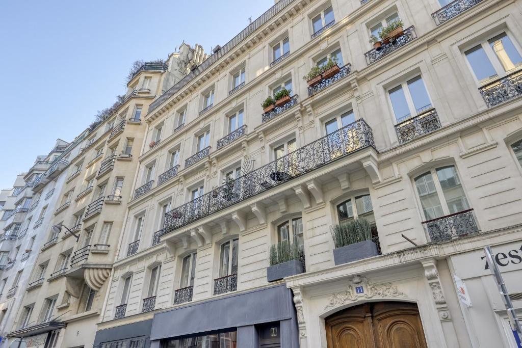 a large white building with windows and balconies at Gorgeous and large flat in the heart of Paris 09 in Paris