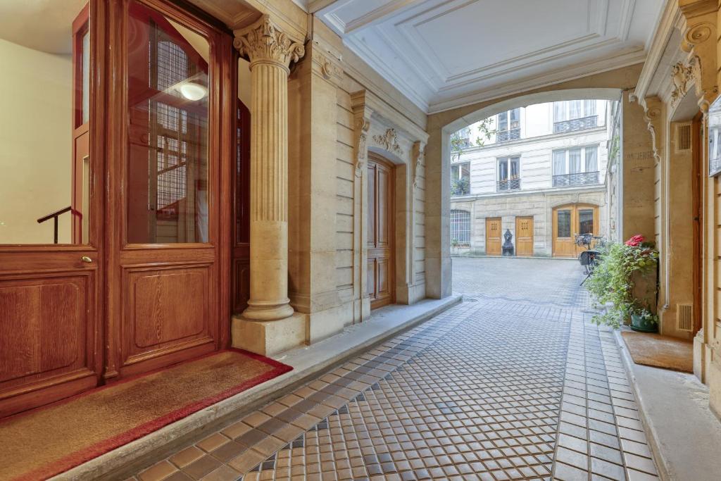 an empty hallway of a building with a large wooden door at Gorgeous and large flat in the heart of Paris 09 in Paris