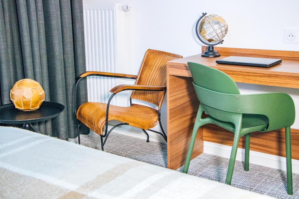 a hotel room with a desk and two chairs at The Originals Residence, Le Wax, Lille Est in Villeneuve d&#39;Ascq