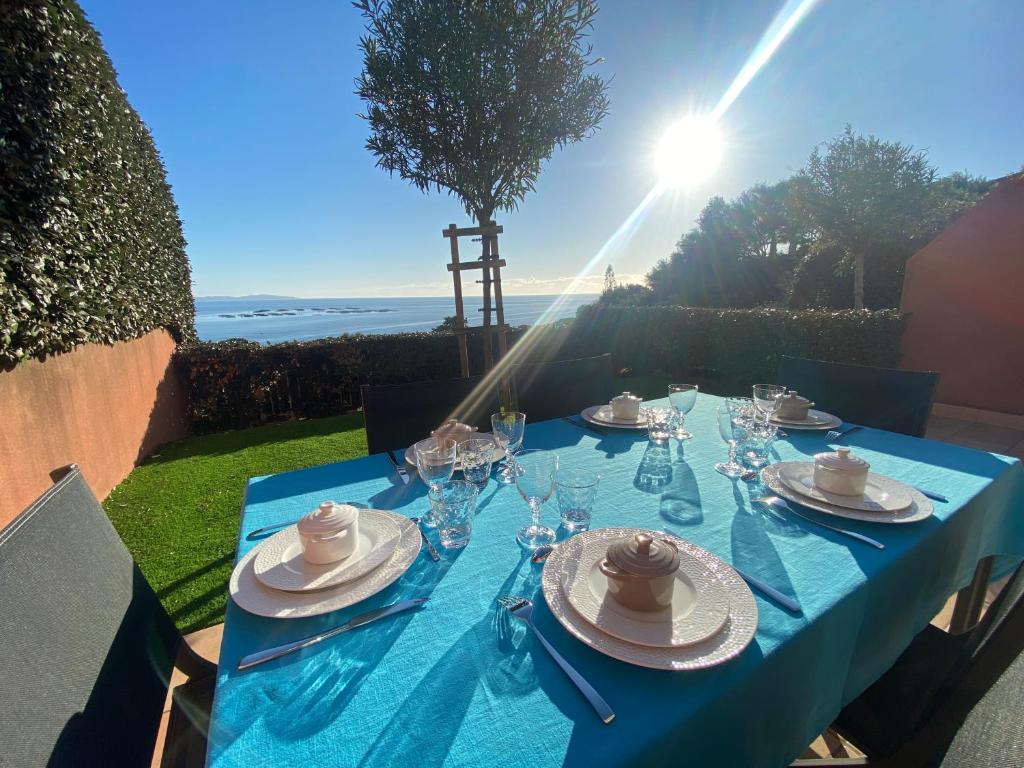 Mini villa Hameaux des Sanguinaires AJACCIO في أجاكسيو: طاولة مع قماش الطاولة الزرقاء وكؤوس النبيذ