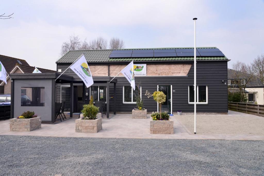 a black building with flags in front of it at Guest House Aan de Hollandse IJssel in Montfoort