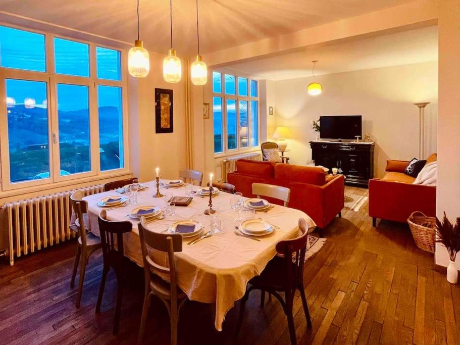 een woonkamer met een tafel en een bank bij La Maison Grise - vacances familiales in Le Tholy