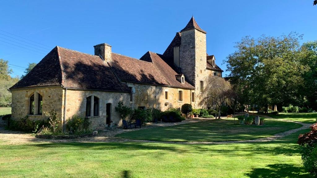 ル・ヴィガンにあるManoir La Barriere - Lotの草の庭のある古い石造りの家