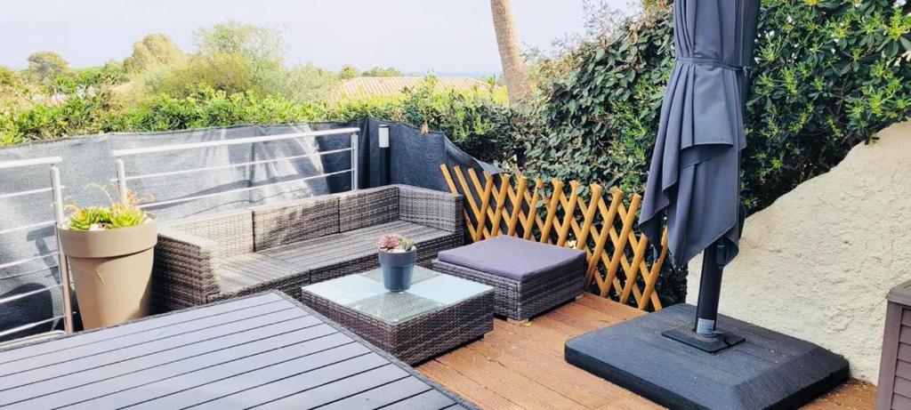 un patio avec un parasol, une table et des chaises dans l'établissement Appartement Aria Marina 1 Lumio, à Lumio