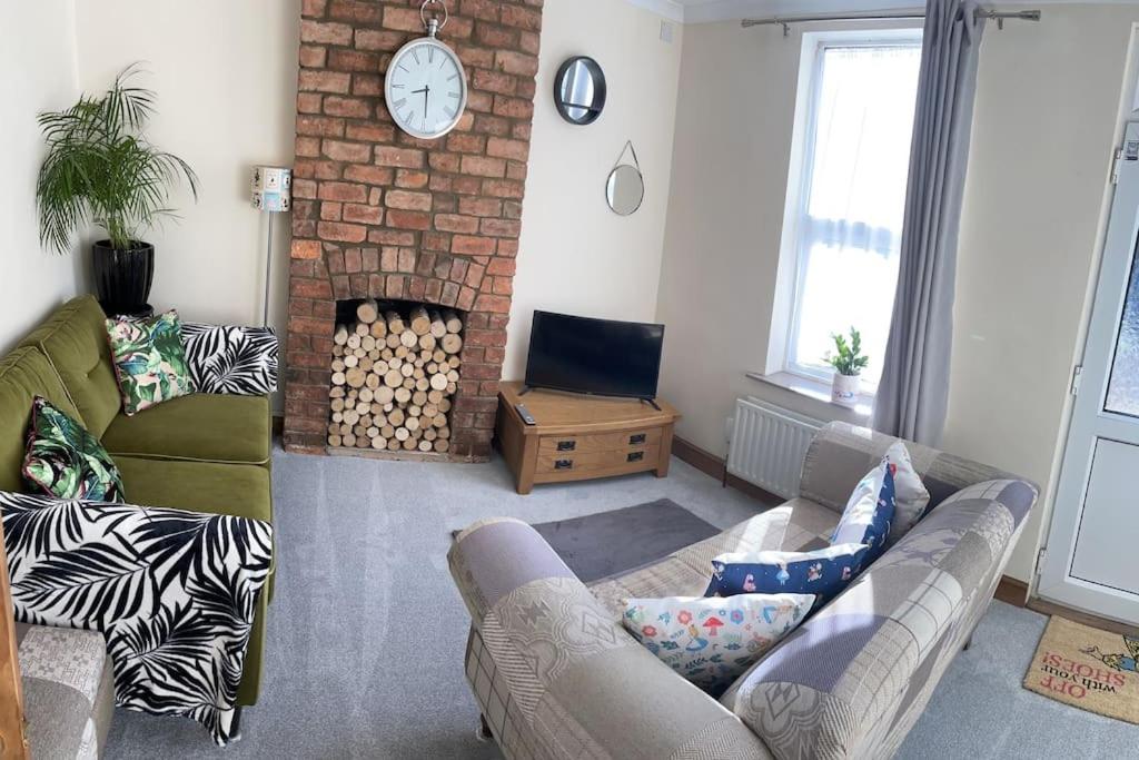 - un salon avec un canapé et une cheminée dans l'établissement Wonderland!, à Lincolnshire