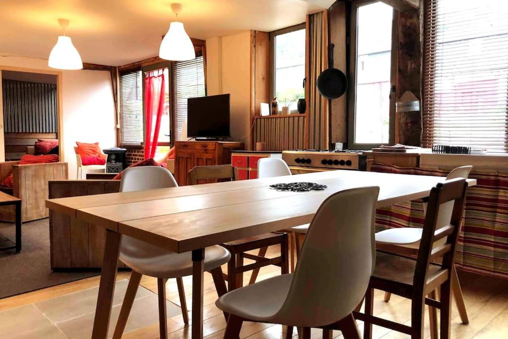 une salle à manger avec une table et des chaises en bois dans l'établissement le relais st nicol, avec terrasse de 50m2 et parking privé, à Honfleur