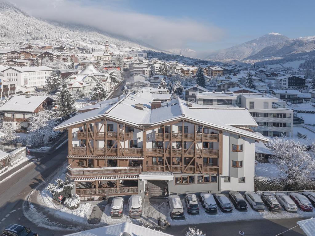 widok z powietrza na budynek z pokrytym śniegiem dachem w obiekcie Alpenhotel Tirolerhof w mieście Fulpmes