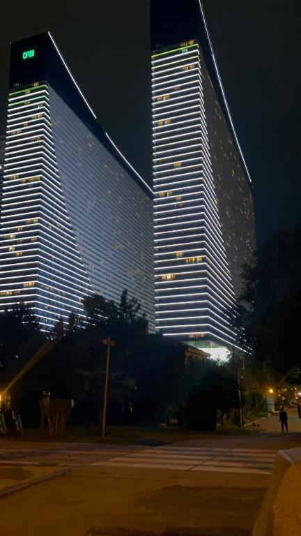 um grande edifício é iluminado à noite em Elite Class Sea View ApartHotel in Orbi city em Batumi