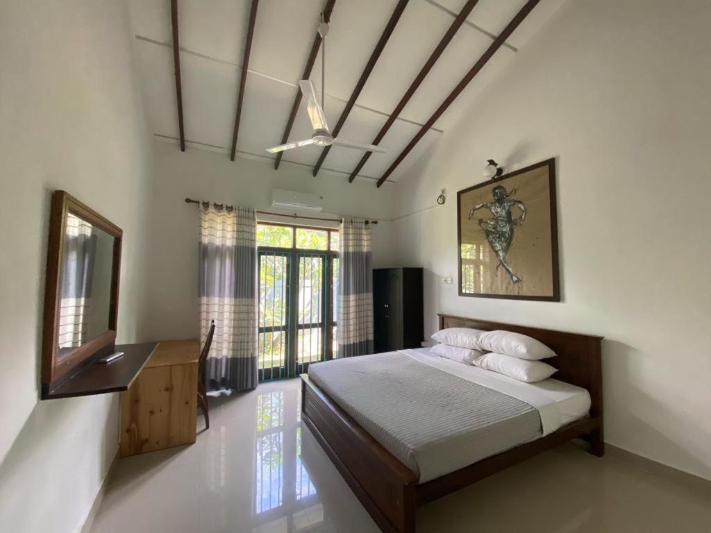 une chambre avec un lit, un miroir et une fenêtre dans l'établissement Lady Nelly villa Hikkaduwa, à Hikkaduwa