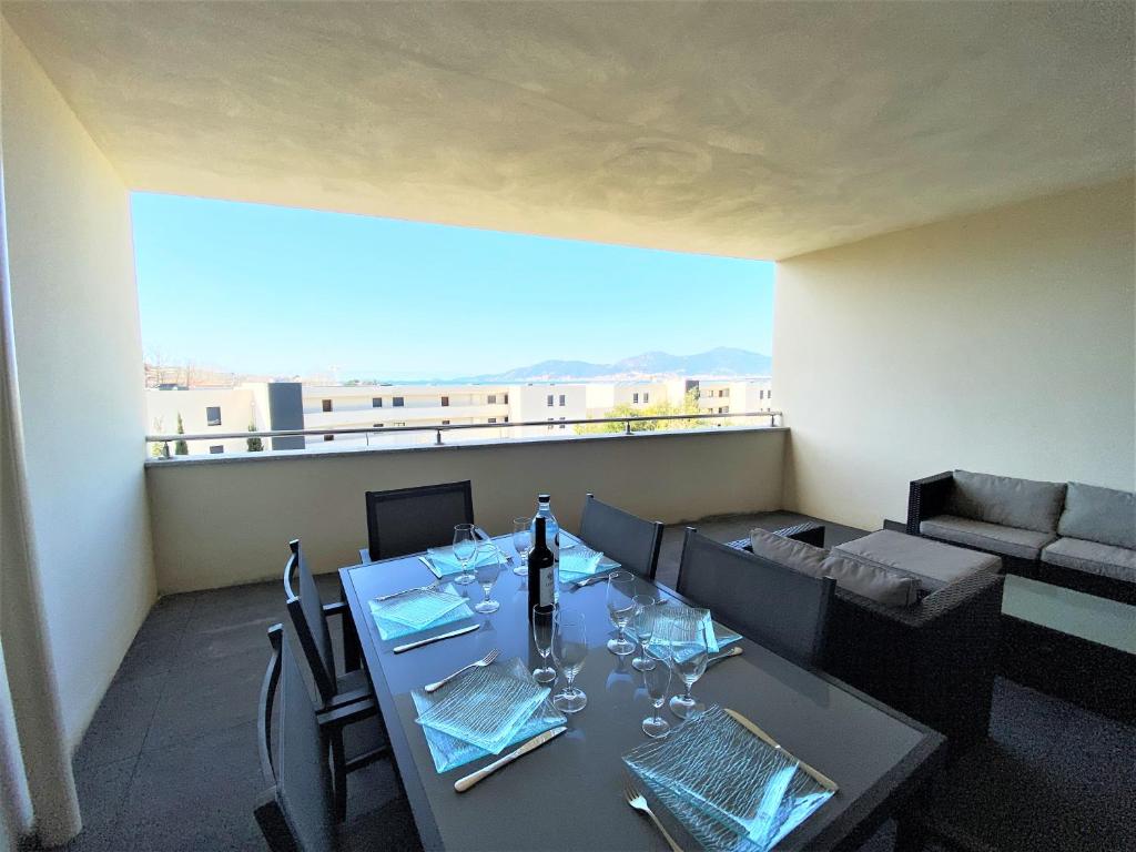 une salle à manger avec une table et un canapé dans l'établissement Appartement Le Frassu PORTICCIO, à Porticcio