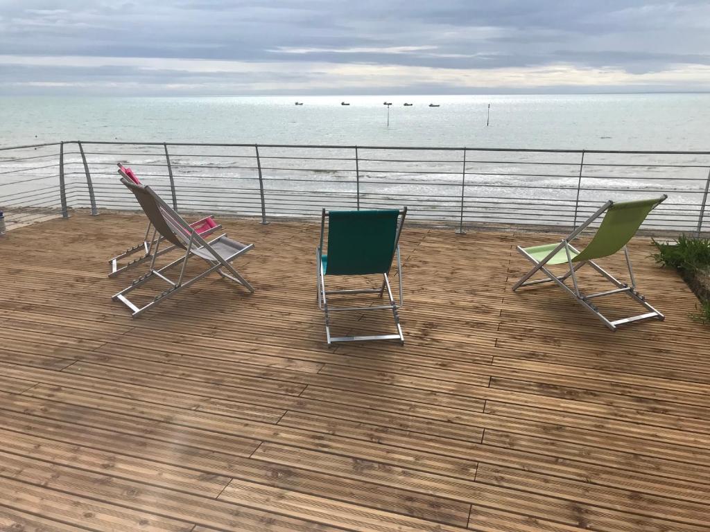 twee stoelen op een terras met uitzicht op de oceaan bij L'Hermitage, villa front de mer in Pirou