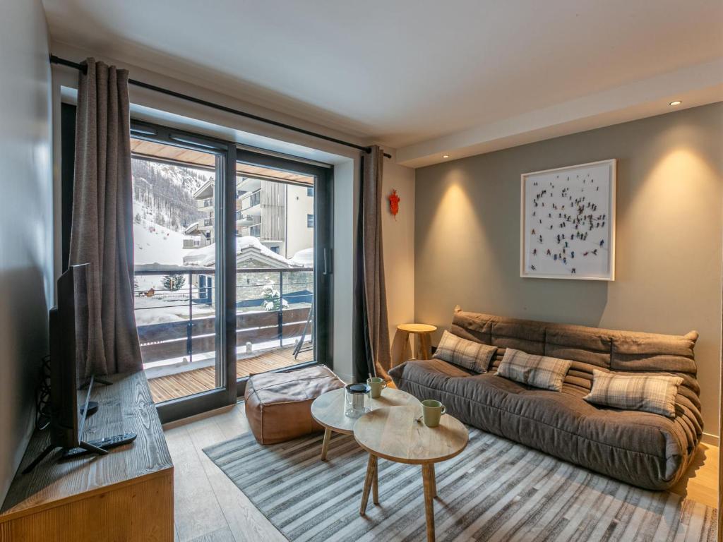a living room with a couch and a large window at Appartement Val-d'Isère, 3 pièces, 4 personnes - FR-1-694-326 in Val-d'Isère
