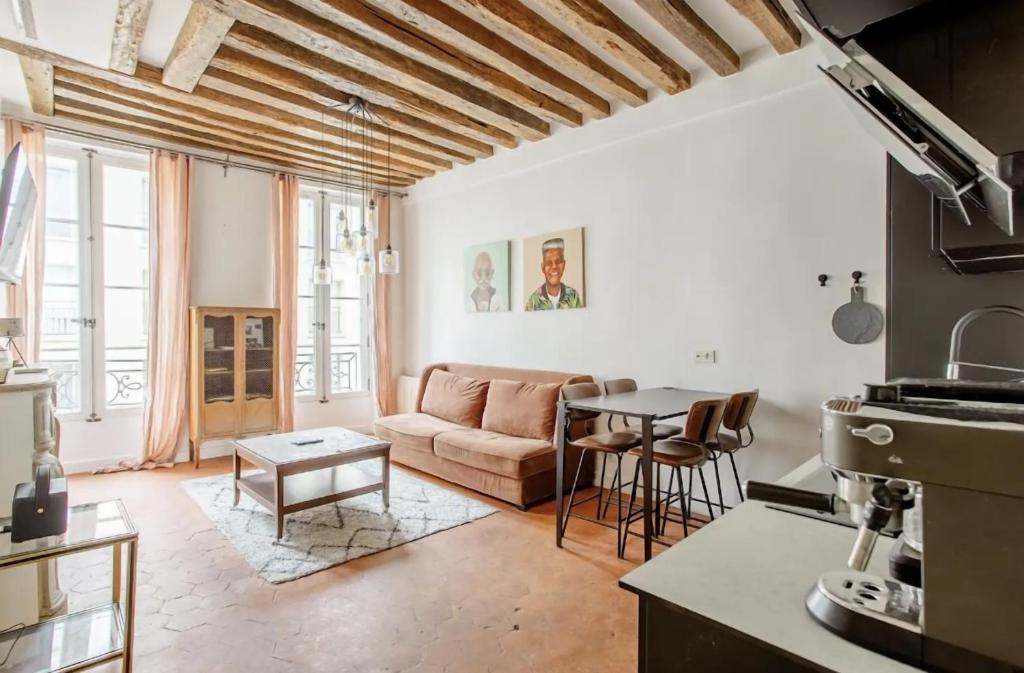 a living room with a couch and a table at Le Clos St Louis in Paris