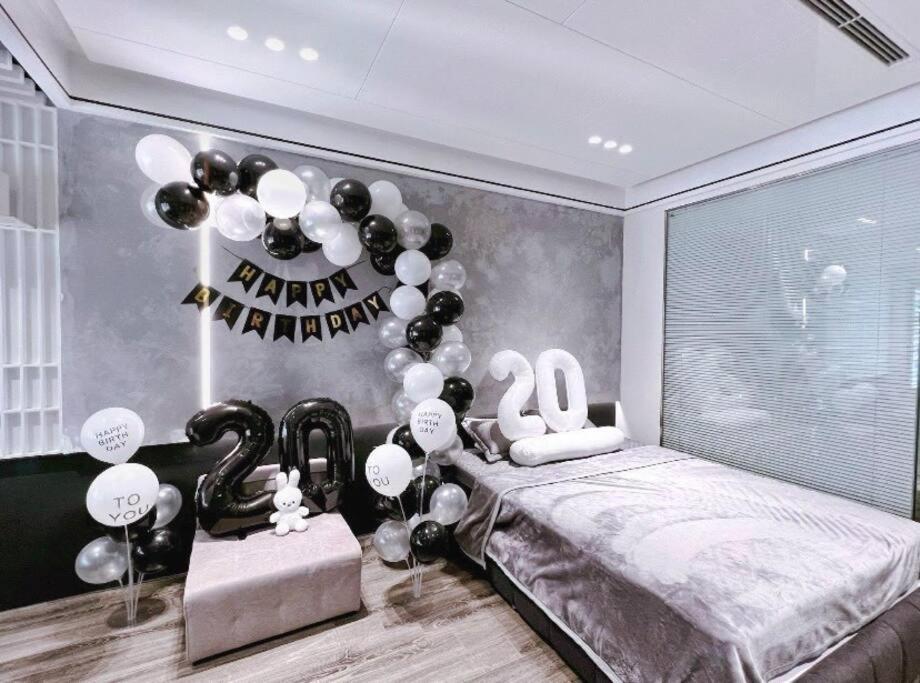 ein Schlafzimmer mit einem fröhlichen Neujahrszeichen und Ballons in der Unterkunft Vinhomes Smartcity - Zhomestay - Căn hộ dich vụ in Thượng Thôn