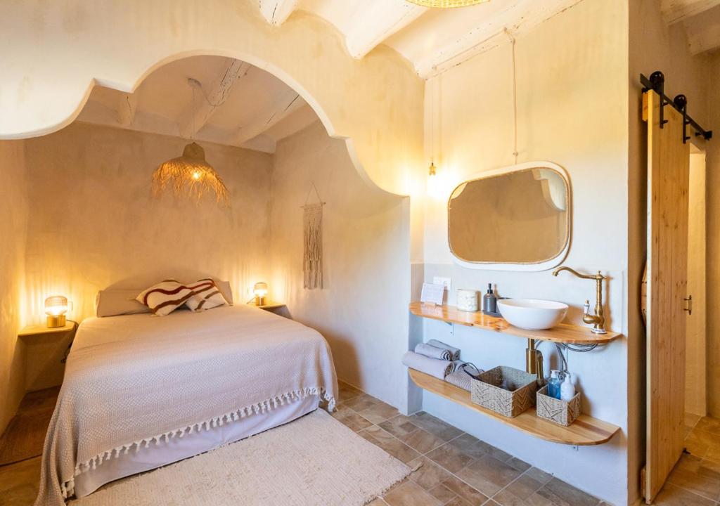 - une chambre avec un lit et un lavabo dans l'établissement Masia Aubareda, à San Martín de Tous