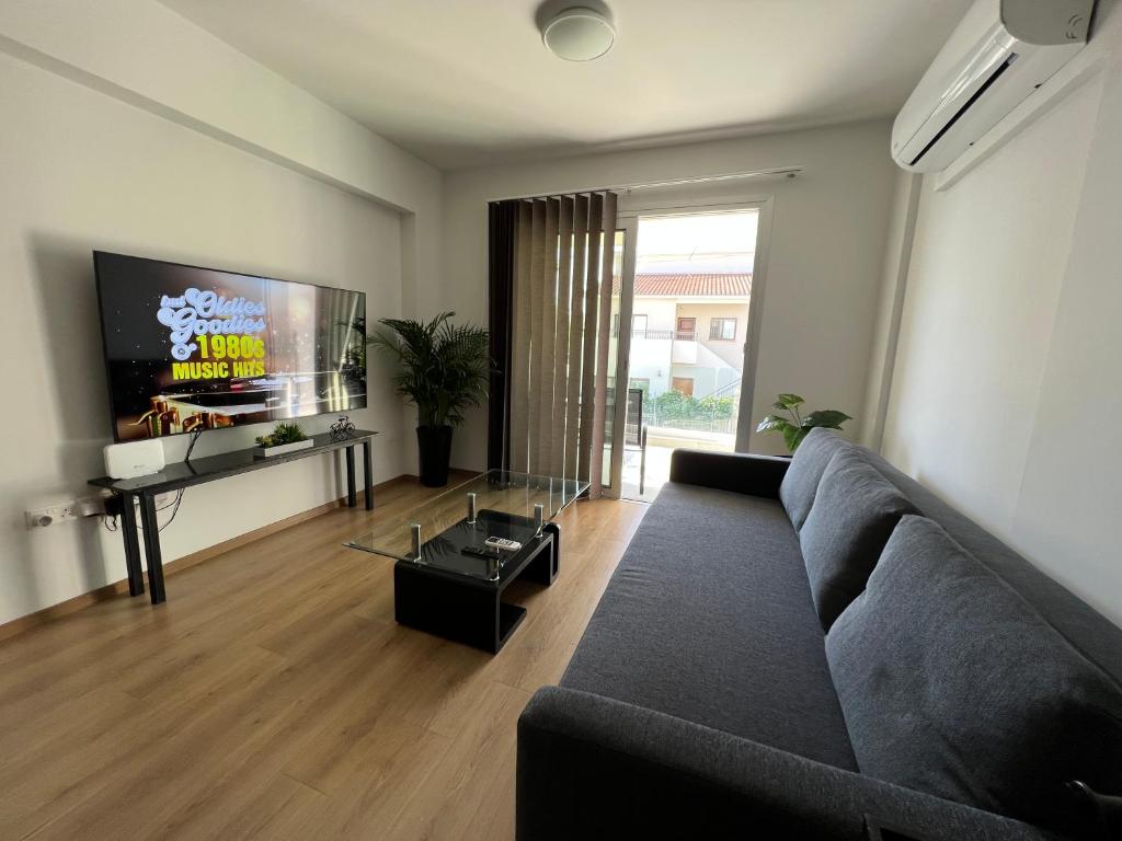 uma sala de estar com um sofá e uma televisão de ecrã plano em Prince Boutique Apartment/1BR em Nicósia